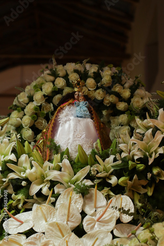 Physical image of the Virgin of La Candelaria surrounded by flowers. Concept of Religion, culture and beliefs (Chacapampa, Peru). photo