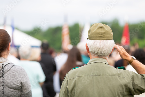 Veteran saluting flag at outdoor event