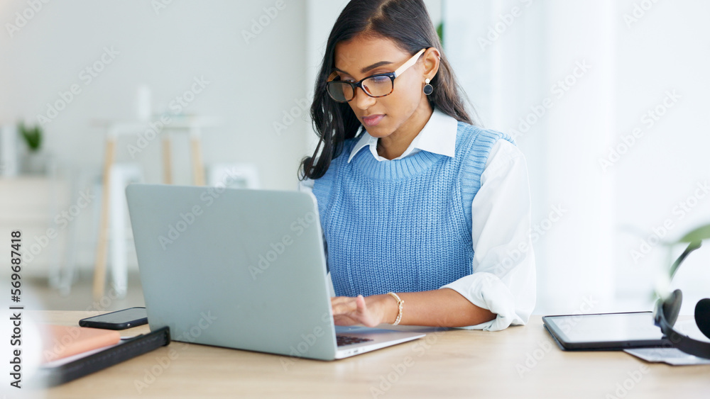 Young woman happily doing business and networking by email on laptop. Professional female is stylish and creative while being alone in office. She is using technology to advance her career Young woman happily doing business and networking by email on laptop. Professional female is stylish and creative while being alone in office. She is using technology to advance her career