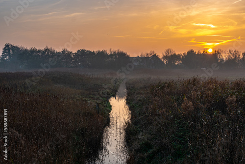 Ground fog in the dusk of the typical flat landscapes of East Frisia in the tourist resort Norddeich directly at the north sea behind the dike photo