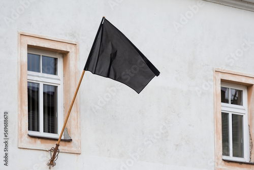 Εκτύπωση καμβά A black flag hanging under the window on the facade of the building