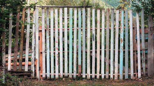 Old wooden rustic color fence, property border with nature background © Luka