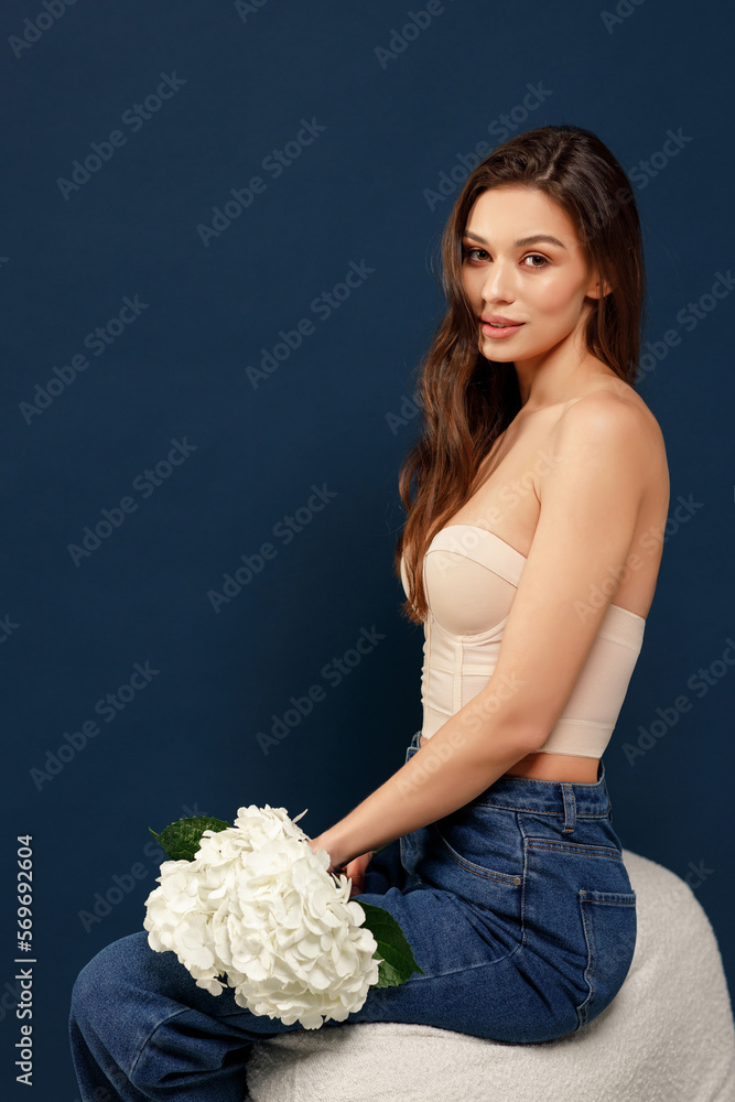 Φωτογραφία Portrait of smiling beautiful young girl with perfect glowing skin and bare shoulders on blue studio background