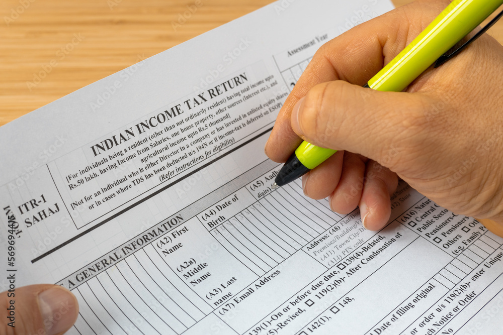 Φωτογραφία Income tax return in India, ITR1 form and hand with pen of the person completing