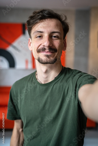 Fotografie One man young adult caucasian male standing at home with brown hair mustaches an