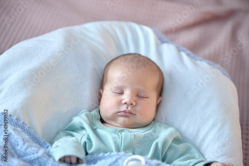 the newborn boy is sleeping. cute beautiful baby is sleeping closeup portrait of a beautiful sleeping baby on white.