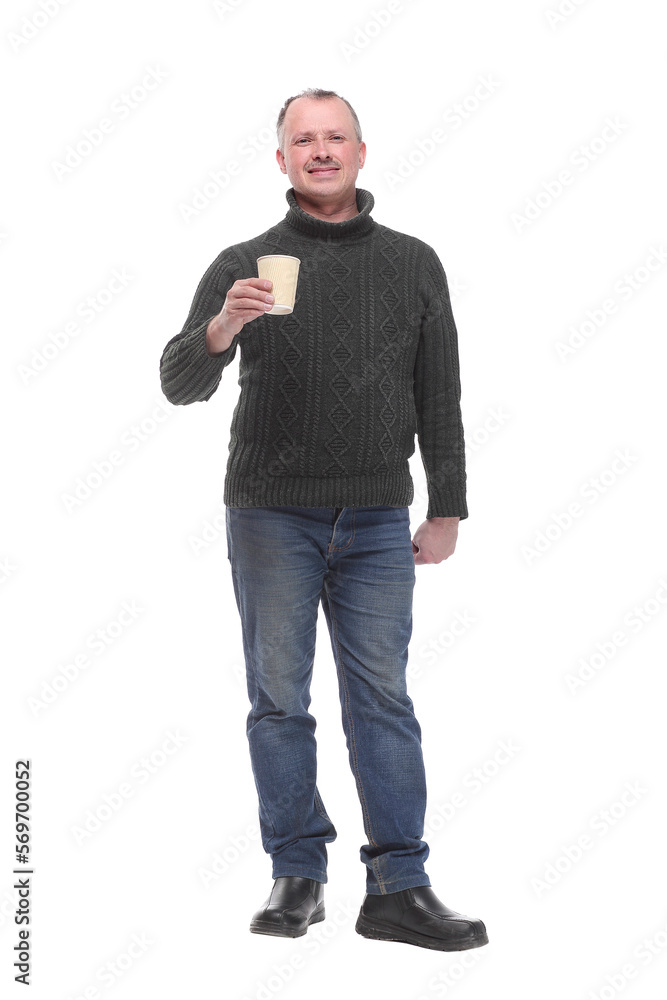 Confident handsome man in jeans holding cup with hot drink and smiling Confident handsome man in jeans holding cup with hot drink and smiling