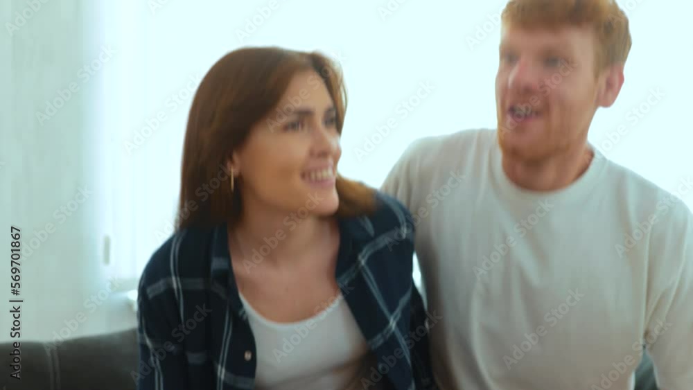 Close up of Caucasian young happy man and woman sitting on sofa in new house with many cardboard boxes on moving day. Family couple moved in together in own home. Mortgage apartment. Real time Close up of Caucasian young happy man and woman sitting on sofa in new house with many cardboard boxes on moving day. Family couple moved in together in own home. Mortgage apartment. Real time