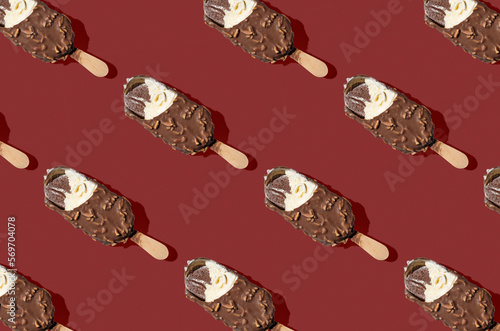 Pattern of chocolate ice cream on a stick on red background