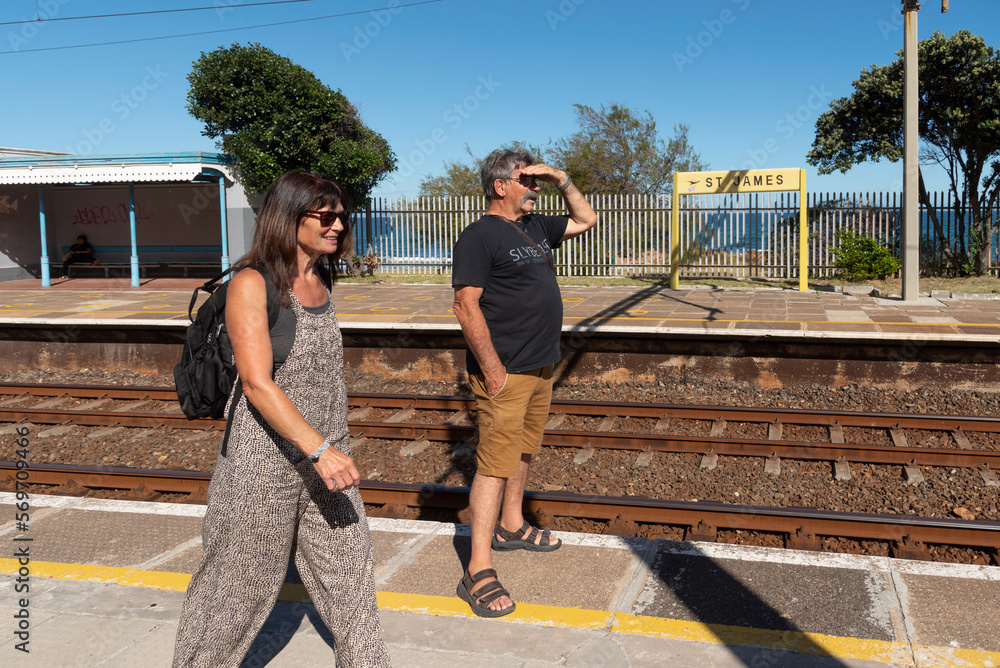 St James railway station Western Cape, South Africa. 2023. Tourists wait for a passenger train on the platform of St James Station