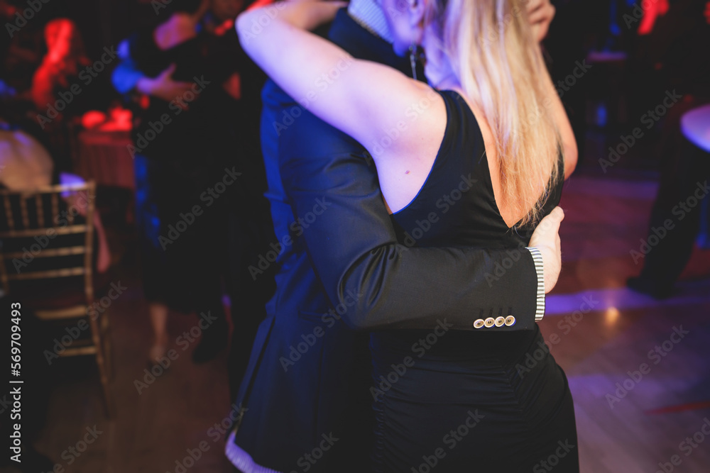 Couples dancing traditional latin argentinian dance milonga in the ballroom on a festival, tango studio, salsa, bachata and kizomba lesson in the red and purple lights, rehearsal in the dance class - obrazy, fototapety, plakaty 