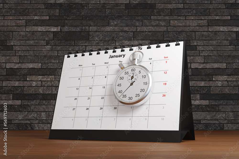 Stopwatch hung on a desktop calendar on an office wooden desk