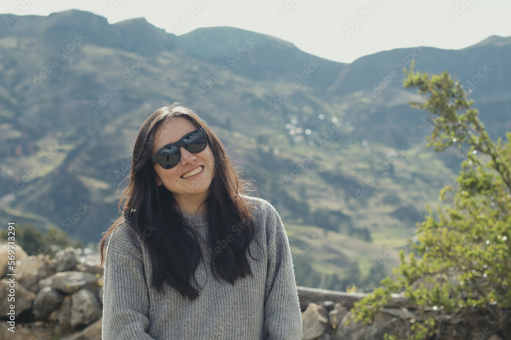 Portrait of a tourist woman enjoying her vacation in a mountain landscape in the Andes Mountains (South America). Concept professions, people, travel and vacations.
