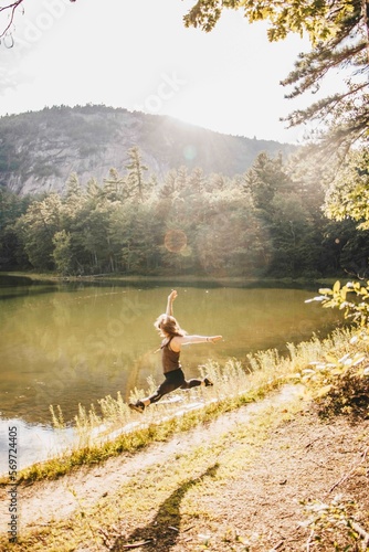 woman dancing in front of a lake and mountain 