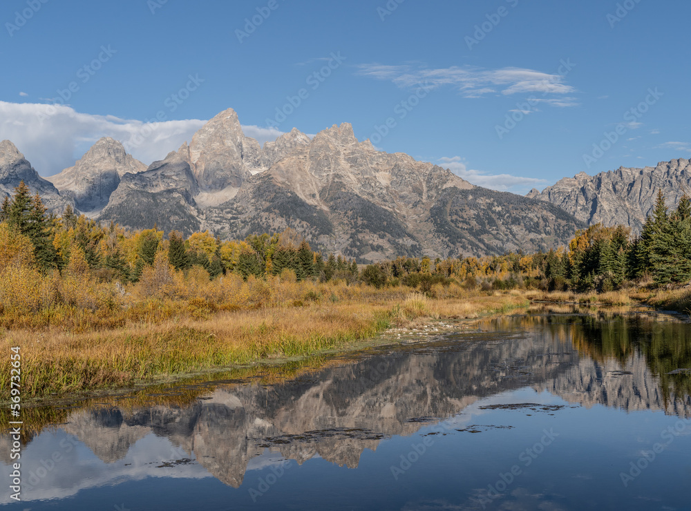 Grand Teton Mountain Range with autumn colors reflect in water of Snake River at Schwabacher’s Landing, Grand Teton National Park