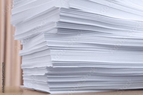 Stack of paper sheets on wooden table indoors, closeup
