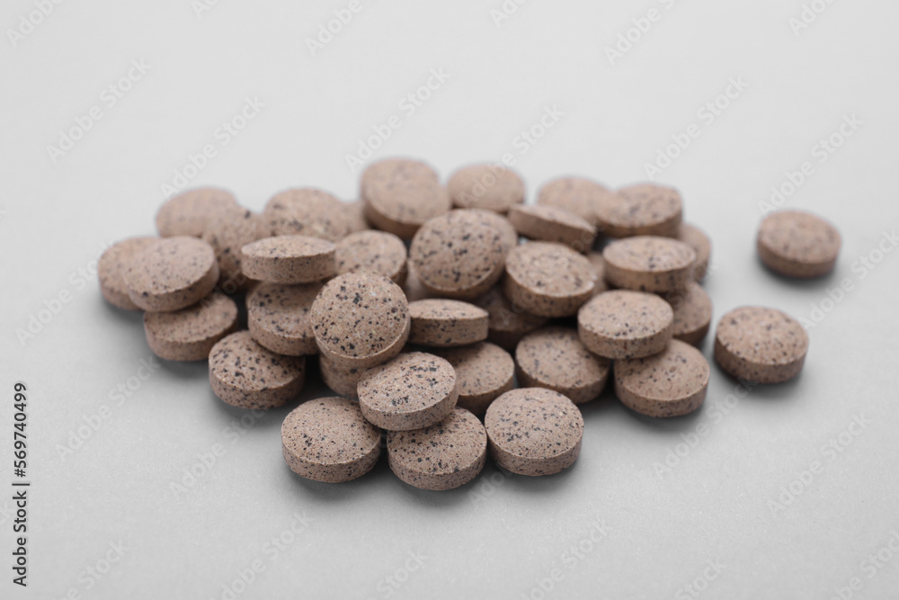 Brewer`s yeast tablets on light grey background, closeup Brewer`s yeast tablets on light grey background, closeup
