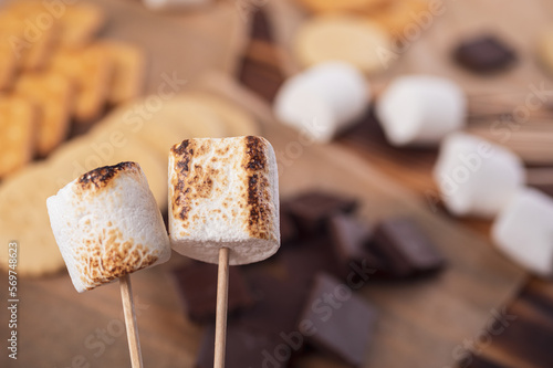 Fototapeta Naklejka Na Ścianę i Meble -  marshmallows, chocolate and cookies for making smore on brown background. view from above. copy space