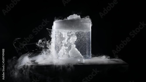 Clear square container with dry ice bubbling and emitting clouds of vapor