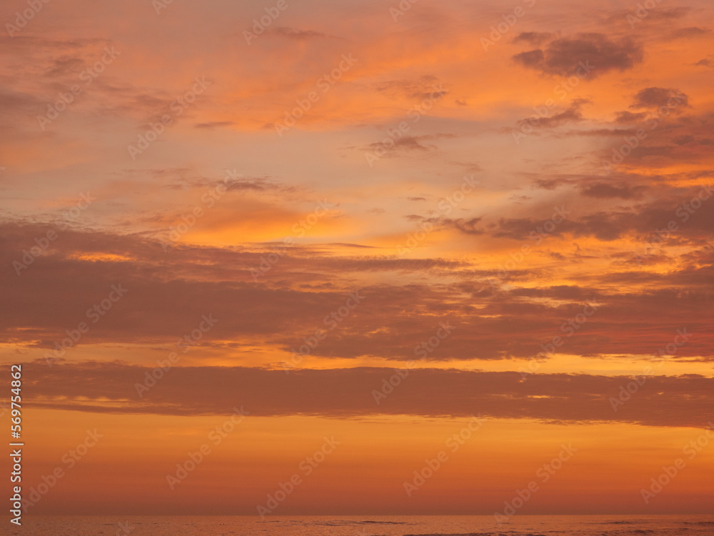 Sunset on the beach, golden hour, the sky is painted in orange and yellow colors