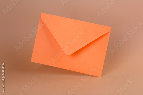 Orange paper envelope on color background
