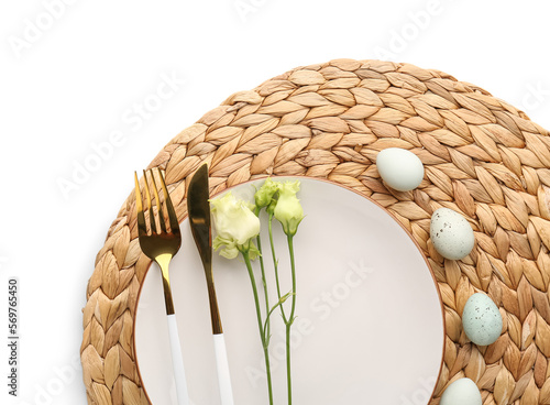 Table setting with Easter eggs  cutlery and eustoma flowers isolated on white background