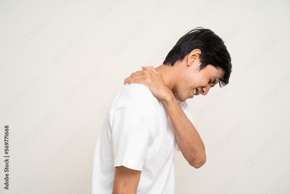 Young Asian man has problem with structural posture He had neck and shoulder pain. Massaged his neck and shoulders for relief. reduce muscle tension. Standing on isolated white background Young Asian man has problem with structural posture He had neck and shoulder pain. Massaged his neck and shoulders for relief. reduce muscle tension. Standing on isolated white background