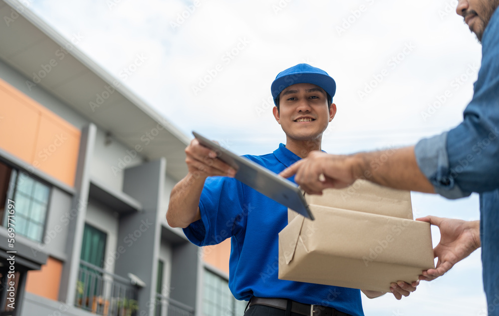 Hand man signing electronic Signature on tablet for agreement of contract digital receiving parcel from blue delivery man from shopping online. Courier man delivering package to destination. Hand man signing electronic Signature on tablet for agreement of contract digital receiving parcel from blue delivery man from shopping online. Courier man delivering package to destination.