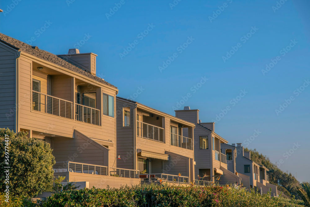 Facade of homes at Del Mar Southern California on a beautiful sunny day. The two-storey beach homes with balconies overlooks the scenic sea landscape and peaceful ocean. Facade of homes at Del Mar Southern California on a beautiful sunny day. The two-storey beach homes with balconies overlooks the scenic sea landscape and peaceful ocean.