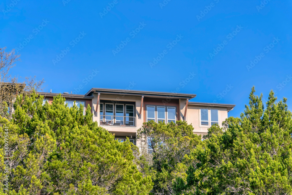 New construction houses by the Lake Austin with trees and blue sky views. Exterior of newly built homes and residential building near the water reservoir in Austin Texas.