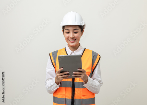 Asian engineer worker woman or architect with white safety helmet standing on isolated white background. Mechanic service factory Professional job occupation in uniform working with tablet