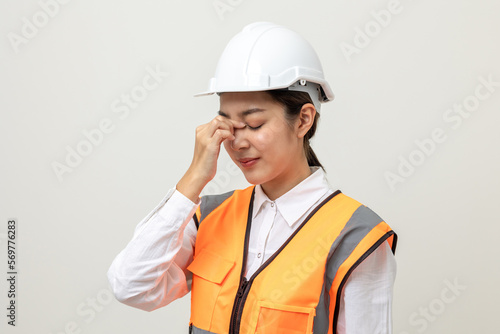 Asian engineer worker woman or architect with white safety helmet standing on isolated white background. Feeling depressed stress headache be tired from working health problems