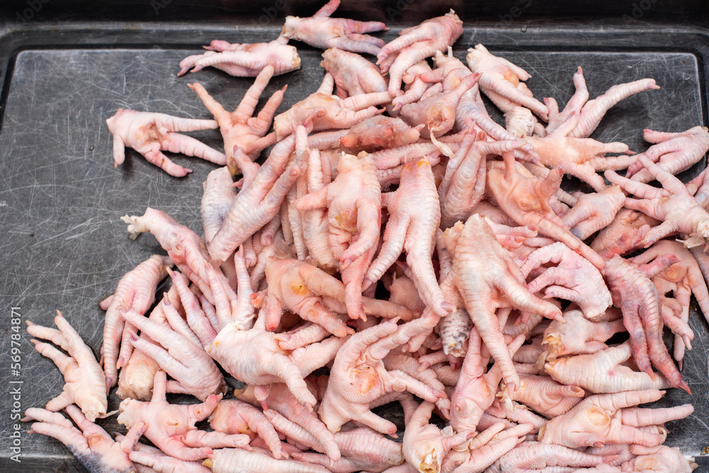 Raw chicken feets in a market stall close-up view in Chengdu, Sichuan province, China