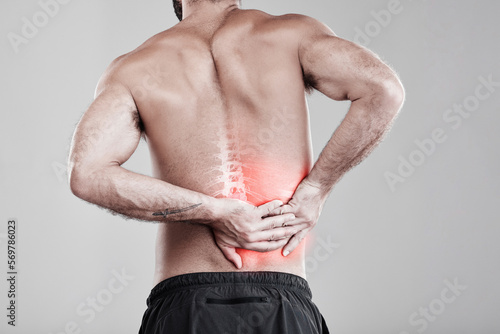 Man, hands and back pain in x ray for injury, bruise or spinal ache against a gray studio background. Male model suffering from broken spine, inflammation or muscle holding painful bone or area photo