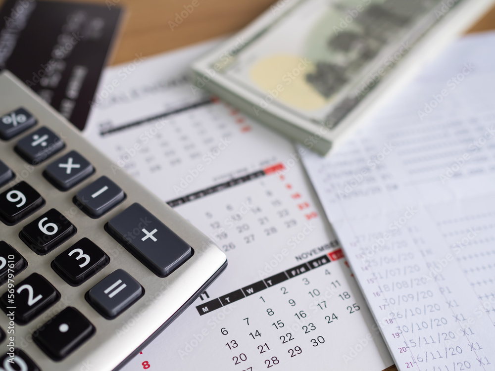 Calculator with Calendar,Money,Book Bank Papter business on Table in Office,Plan Investment Growth Income Finance,Accounting Currency Banking Saving Cash,Deposit Tax Interest Save. Calculator with Calendar,Money,Book Bank Papter business on Table in Office,Plan Investment Growth Income Finance,Accounting Currency Banking Saving Cash,Deposit Tax Interest Save.