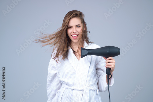 Woman with hair dryer in a studio.