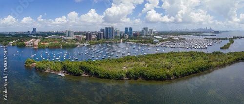 Panoramic view of boats with Miami Florida skyline against blue sky and clouds. High rise condomimiums and buildings overlooking the beautiful manmade inland channel.