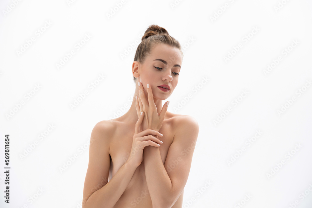 Obraz premium Beautiful young woman with clean skin touches her face
