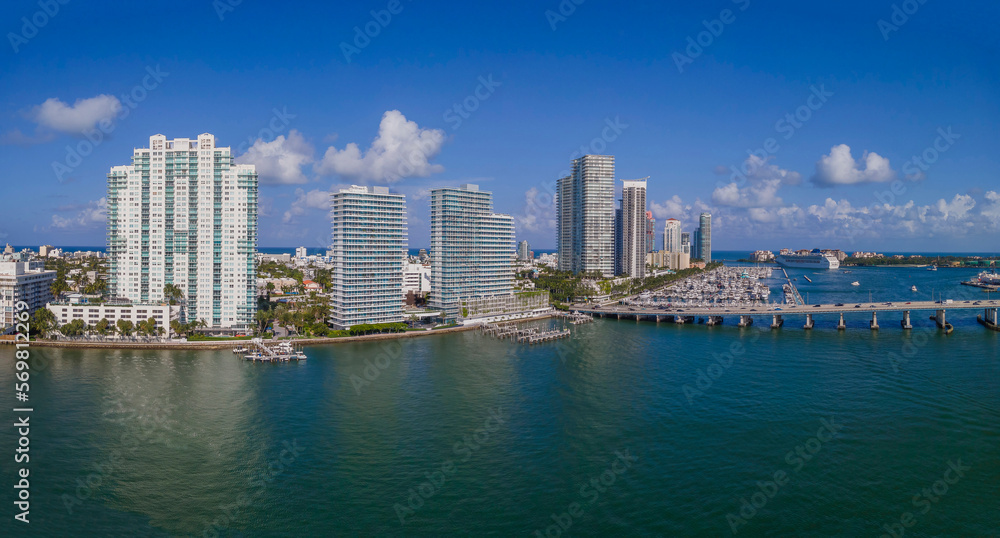 Panorama of builings and highway over Intracoastal Waterway in Miami Florida. Scenic urban skyline against a manmade inland water channel and bright blue sky on a sunny day.