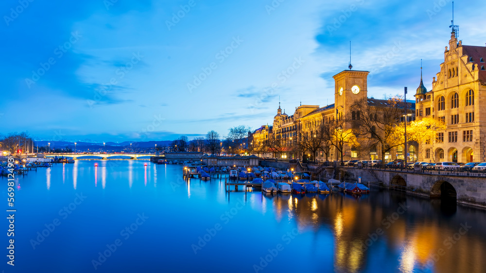 Panorama landscape along Limmat river in twilight sunset with Swiss alps background.Blue sky in the evening.Winter season in Switzerland with reflection on Limmat river.Colorful light cityscape.