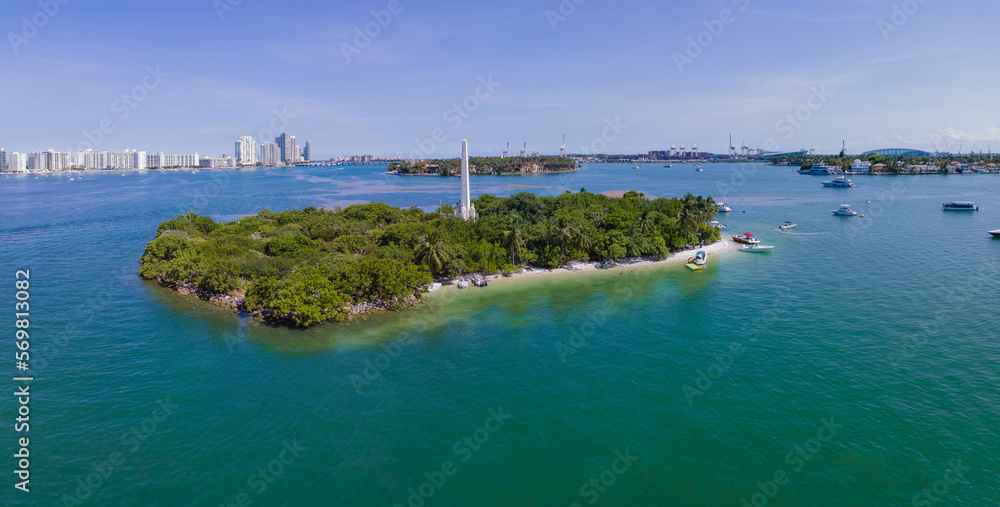 Aerial panorama view of Flagler Memorial Island at Miami Beach, Florida. Island with boats on the shore and waterway against the view of high-rise buildings and sky at the background.