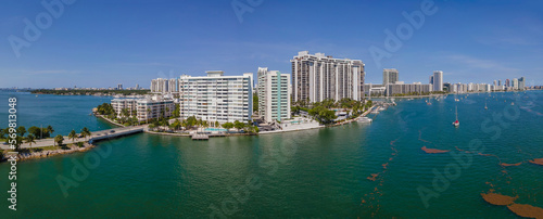 Coastline modern multi-storey buildings at Miami Beach, Florida. Aerial view of a road on the left to the intracoastal city buildings against the blue skyline in panorama.