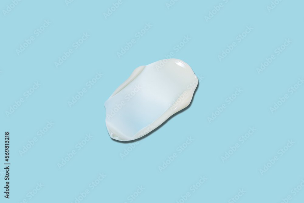 White cosmetic face cream or body lotion moisturizer strokes on pastel blue background. Hygiene, skincare product with creamy texture. Beauty face creme smear swatch on color background White cosmetic face cream or body lotion moisturizer strokes on pastel blue background. Hygiene, skincare product with creamy texture. Beauty face creme smear swatch on color background