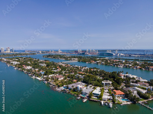 Aerial view of properties amidst the Intracoastal Waterway in Miami Florida. Waterfront homes and buildings has a scenic view of the man-made inland water channel with boats against blue sky.