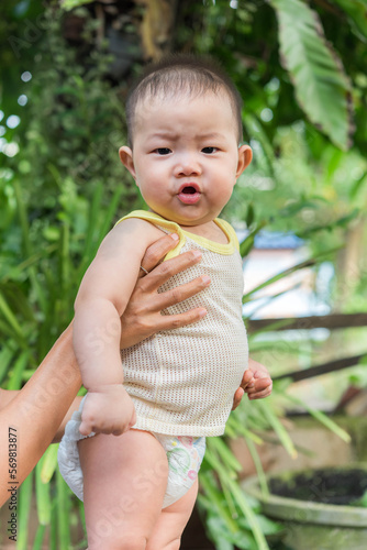 фотографія child lies and starts to babble, 7 months old asian baby boy,baby talk