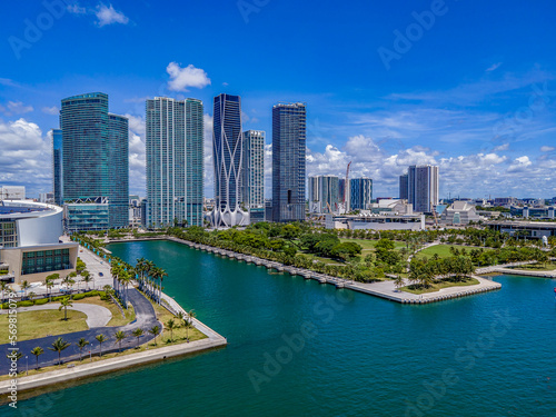 Aerial view of waterway in the middle of Museum Park baywalk at intracoastal Miami Beach, Florida. Park with grass and trees at the front near the water against the high-rise buildings.