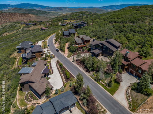 Aerial view of villas near the road on a mountain slope with trees at Park City, Utah. Rich neighborhood on a mountainous area with forest.