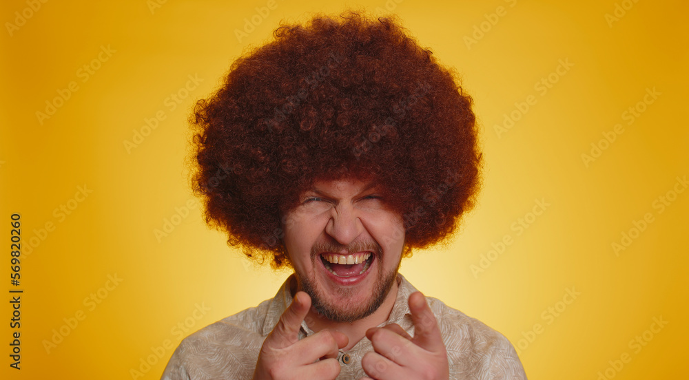 Joyful man with lush Afro hairstyle coiffure laughing out loud after hearing ridiculous anecdote, funny joke, feeling carefree amused, positive people lifestyle. Young hipster guy on yellow background Joyful man with lush Afro hairstyle coiffure laughing out loud after hearing ridiculous anecdote, funny joke, feeling carefree amused, positive people lifestyle. Young hipster guy on yellow background