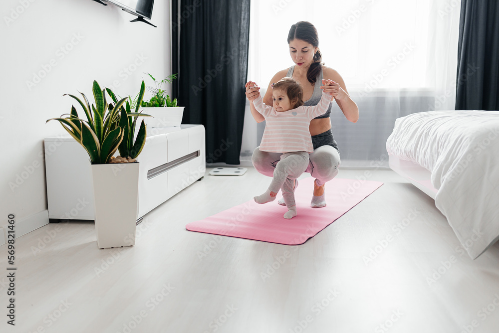 Young sporty mother and baby girl working out, exercising together at home, parent and child healthy development, game playing, fitness and relaxation, Young sporty mother and baby girl working out, exercising together at home, parent and child healthy development, game playing, fitness and relaxation,