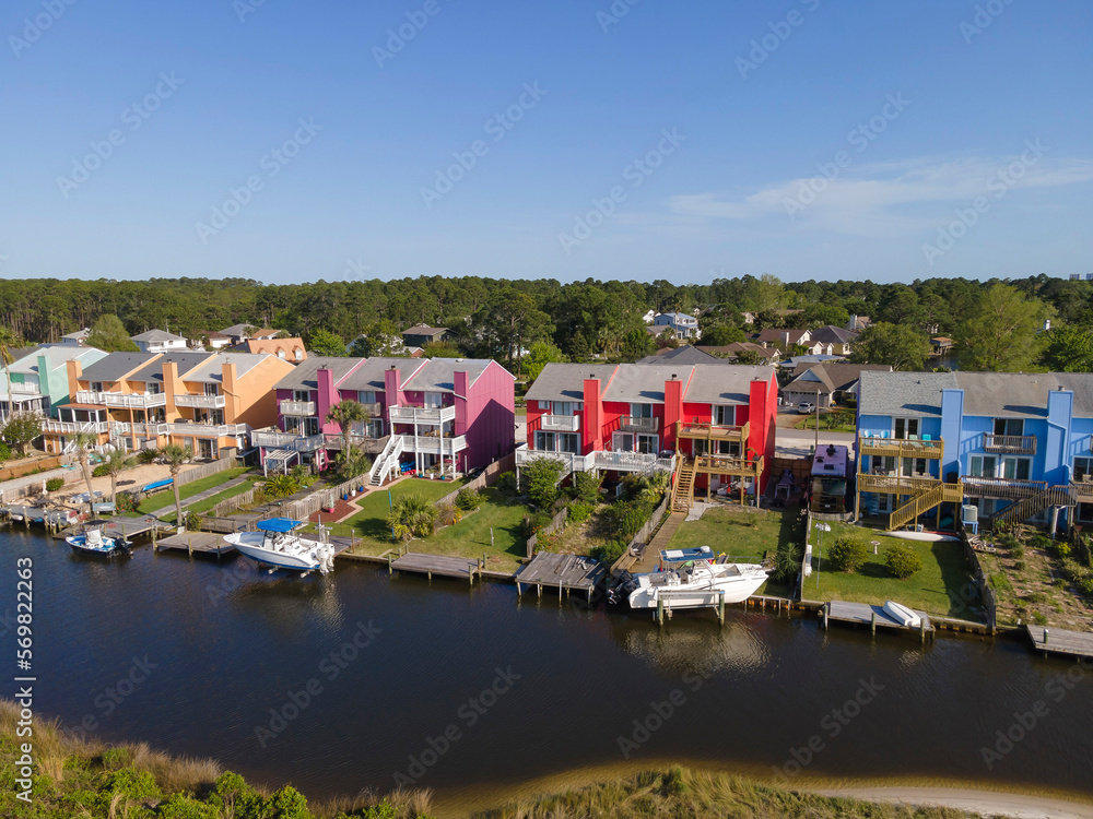 Colorful apartments with balconies facing the waterways at front with boat docks- Navarre, FL. Row of colorful buildings near the waterways in an aerial shot view.